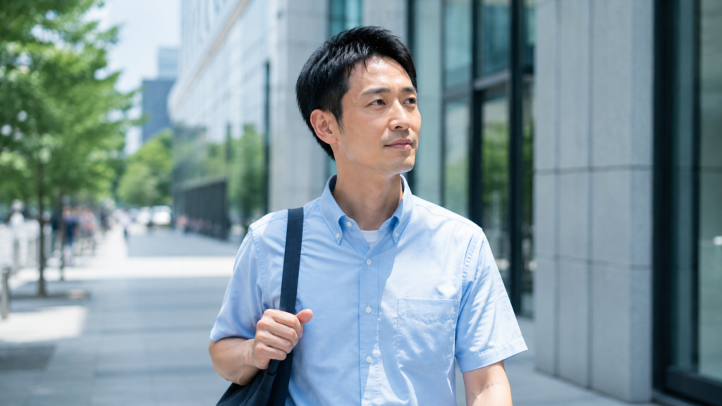 夏の街を歩く半袖シャツ姿の男性
